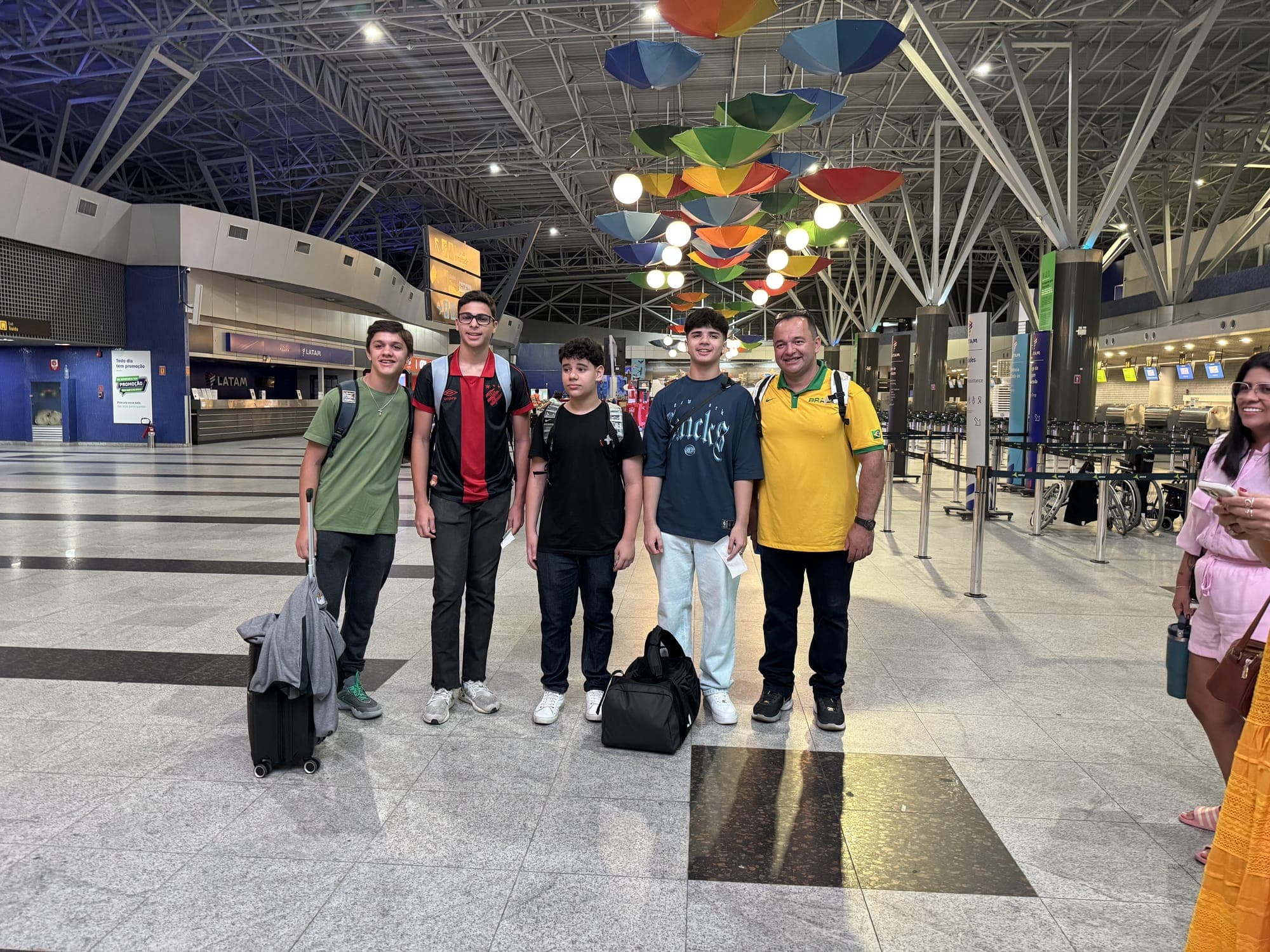 Grupo de alunos com bagagens no terminal do aeroporto antes do embarque